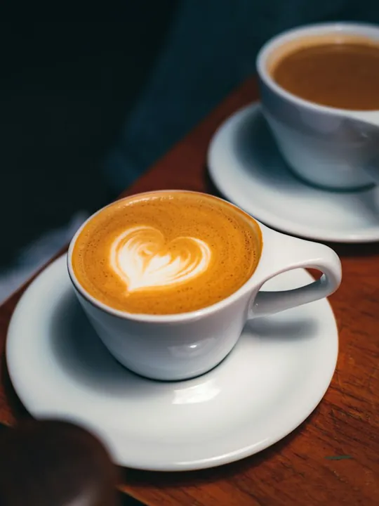 Example photo: two cups of coffee on a wooden cafe table.
