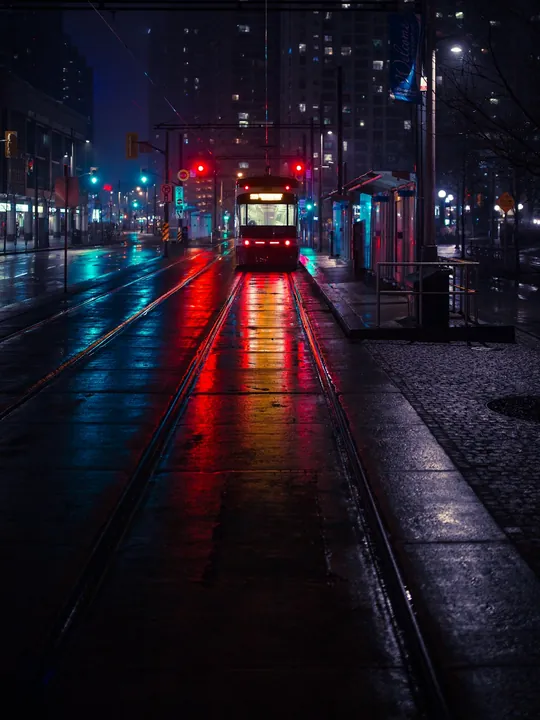 Example photo: a tram on a wet street at night.